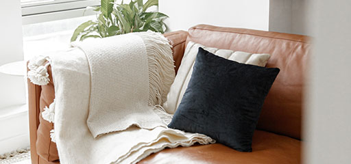 Couch with blanket and pillows.