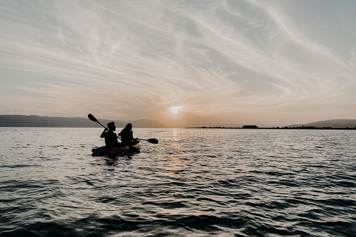 Two friends kayaking together at dawn.