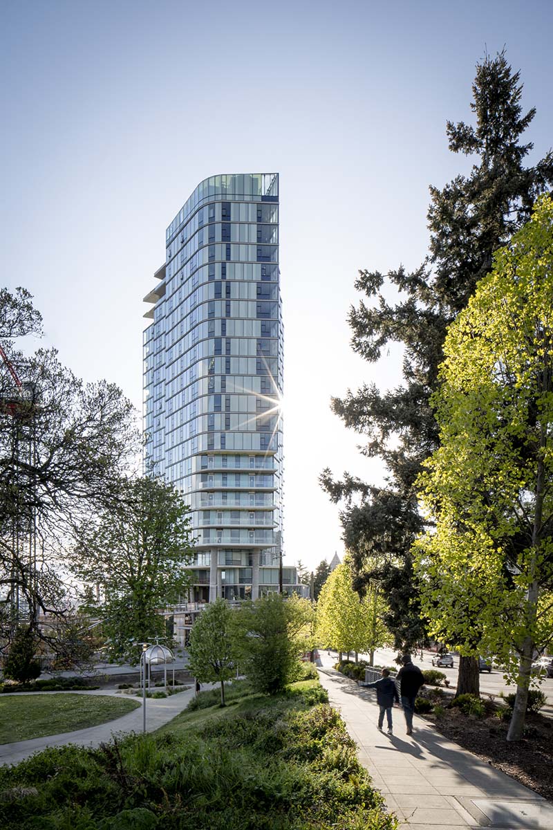 Yesler Tower apartments with modern glass construction and lush surrounding landscape.